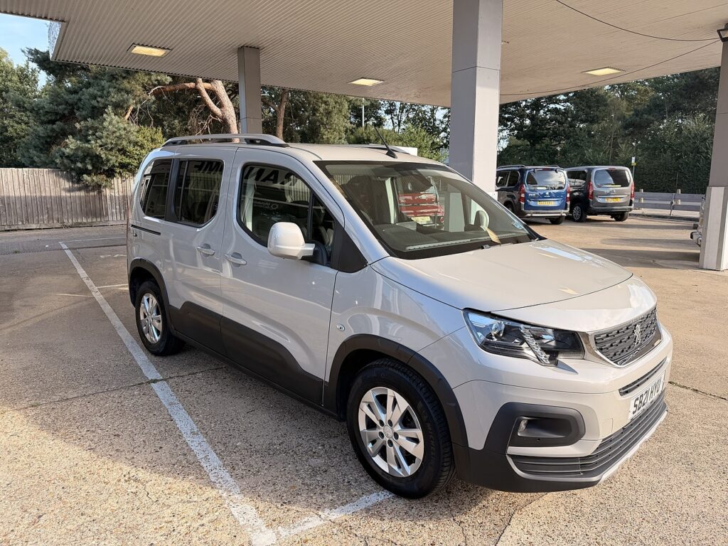 Light silver wheelchair accessible vehicle parked outside in a dealership