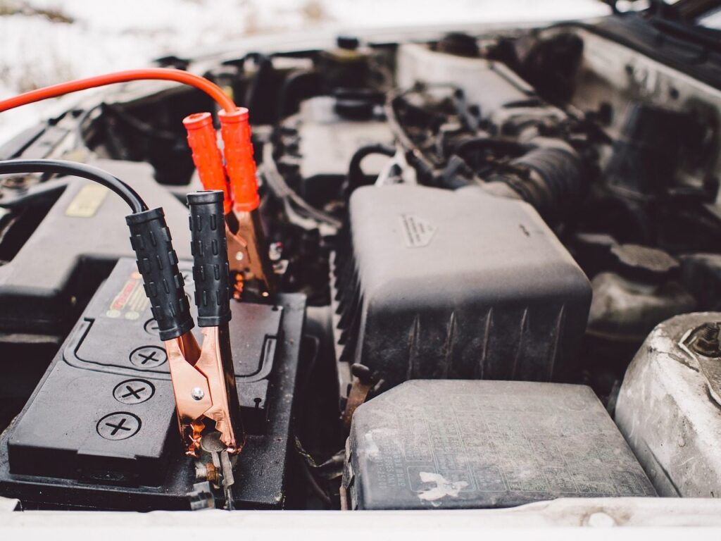 Jump leads clipped to a vehicle battery during a routine check
