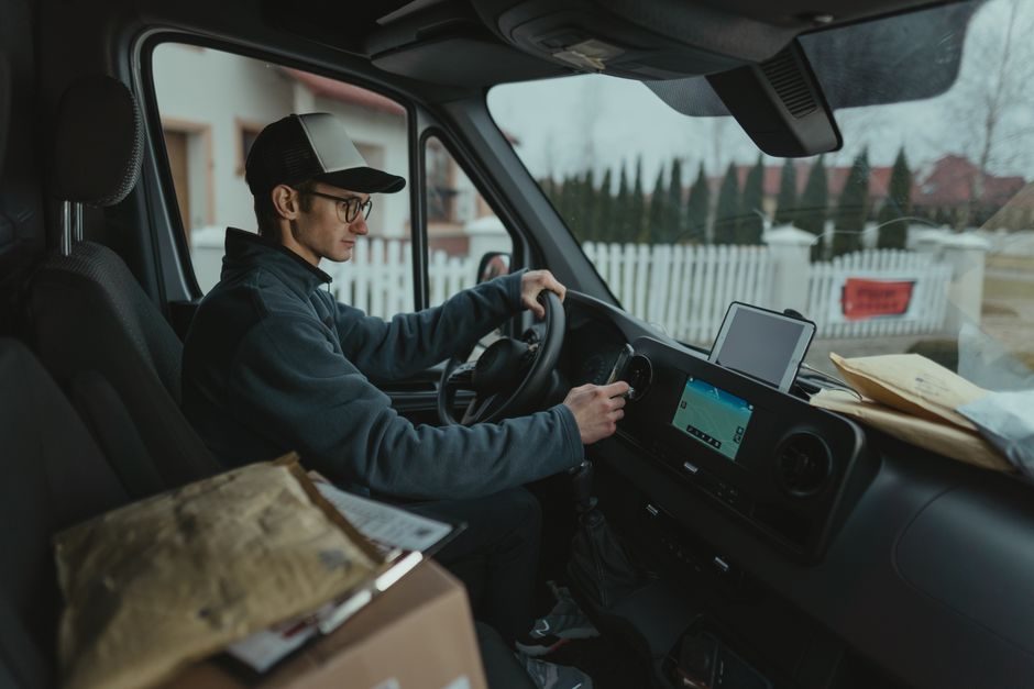 A courier loading parcels into the back of a van