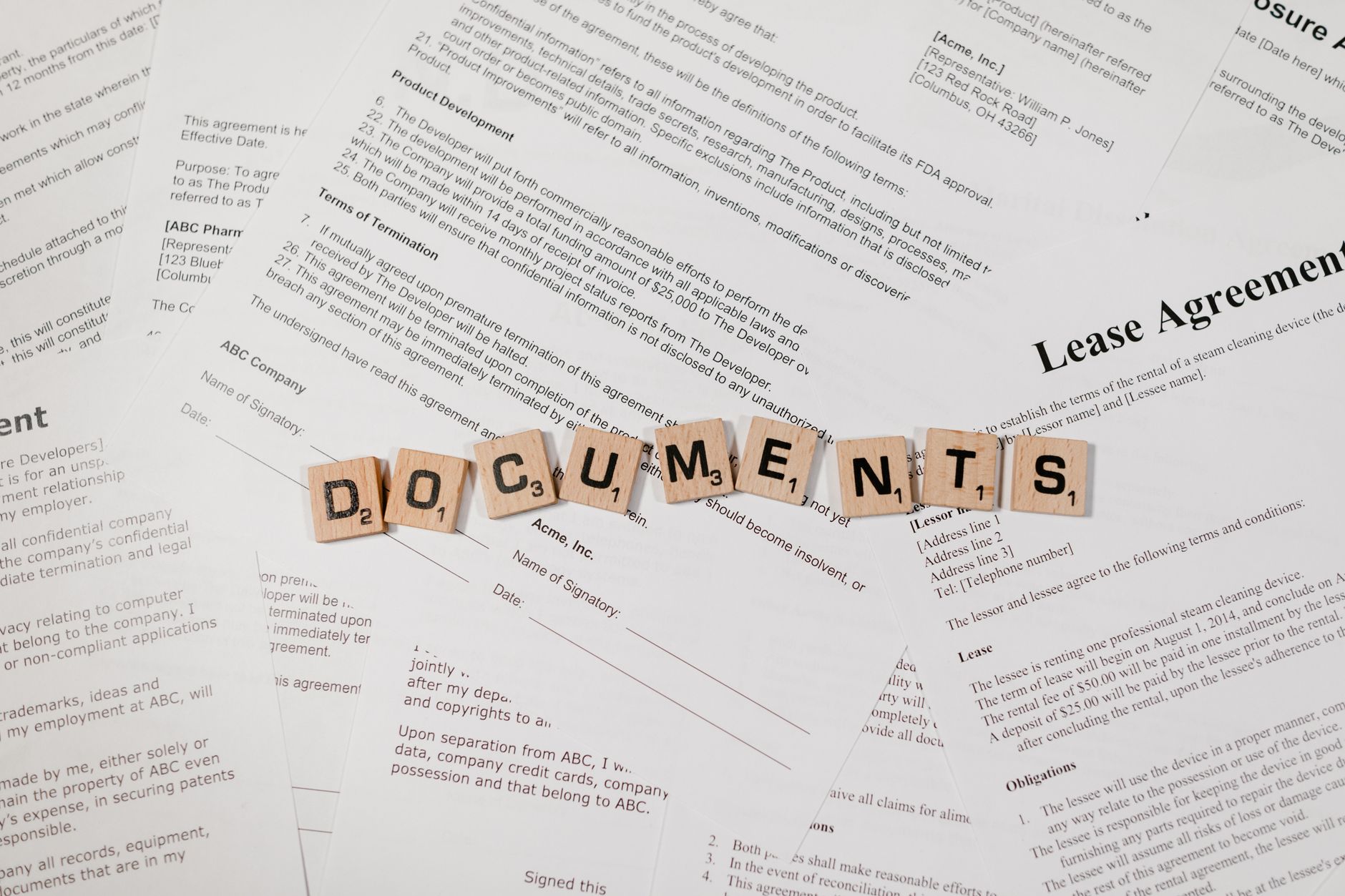 Wooden letter tiles spelling the word agreement laid out on a desk