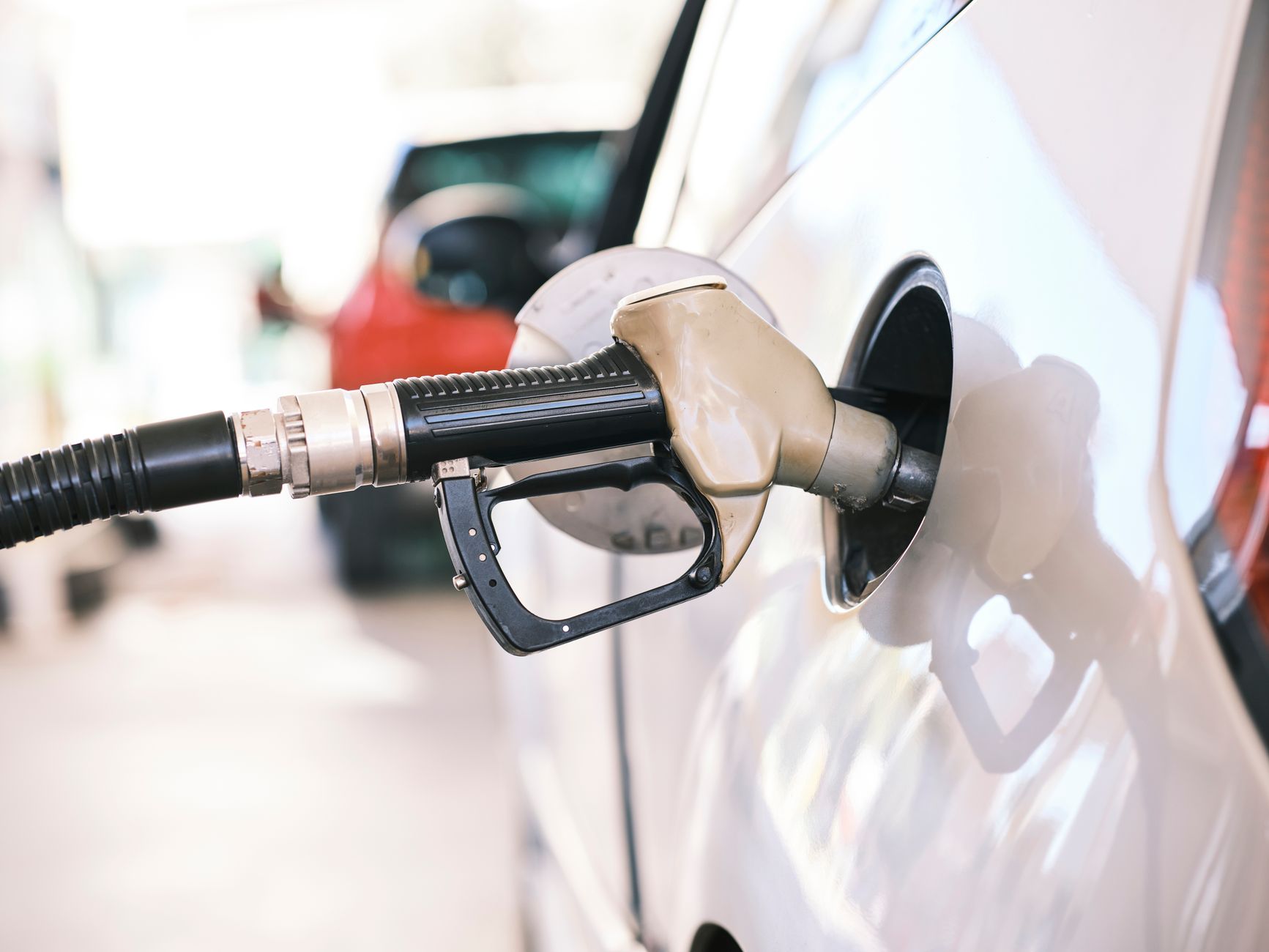 A fuel nozzle inserted into the filler neck of a vehicle, close-up