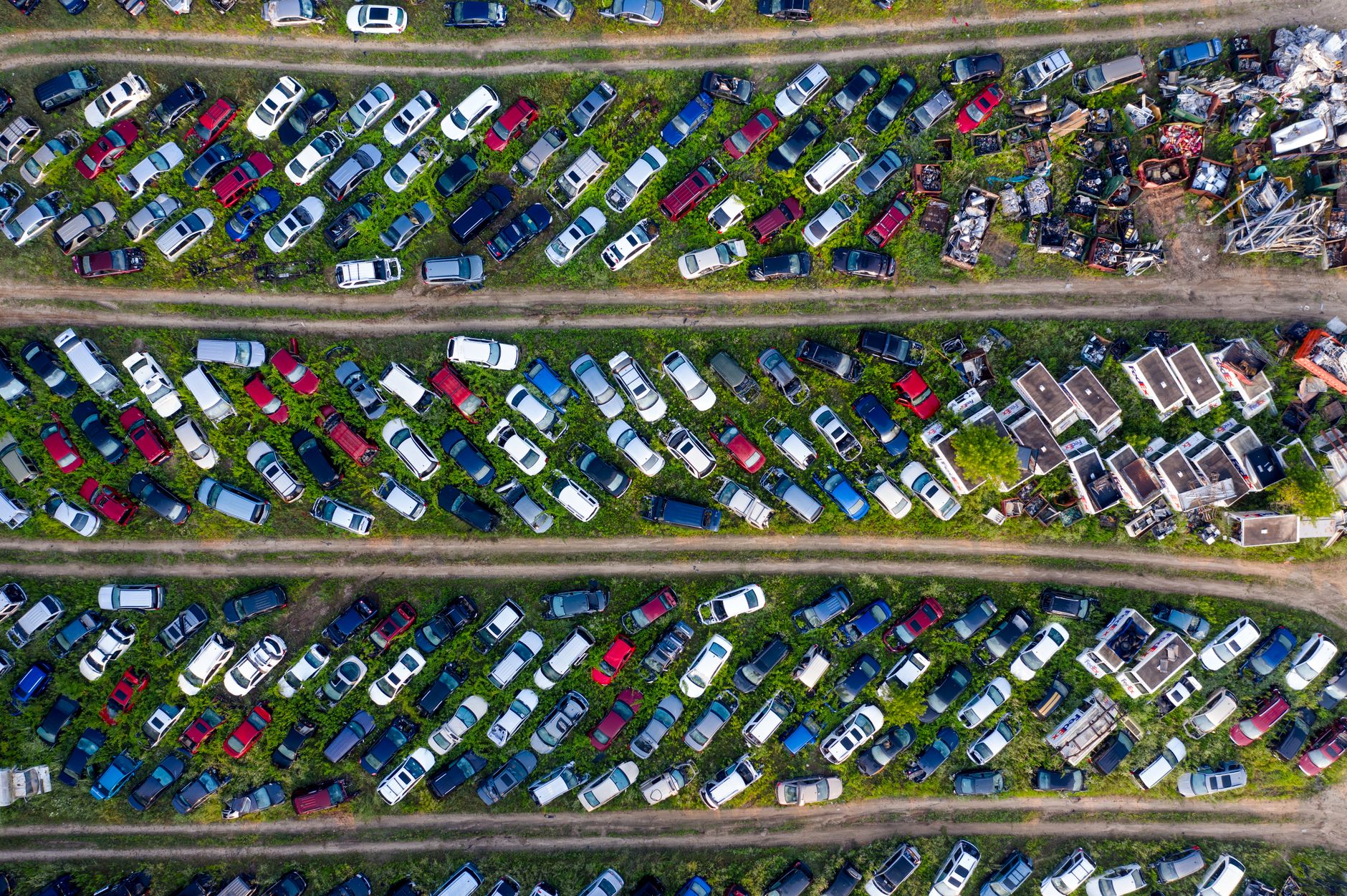 Aerial view of a vehicle salvage yard with rows of cars awaiting dismantling