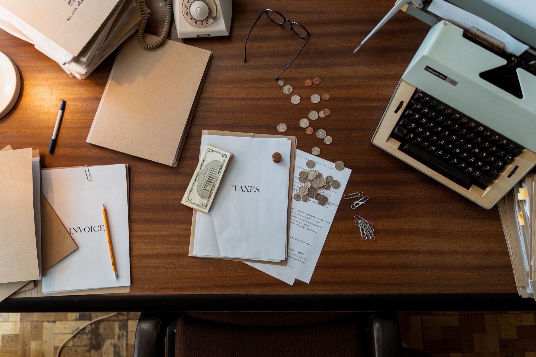 An overhead view of a desk with an open notebook, pens and paperwork
