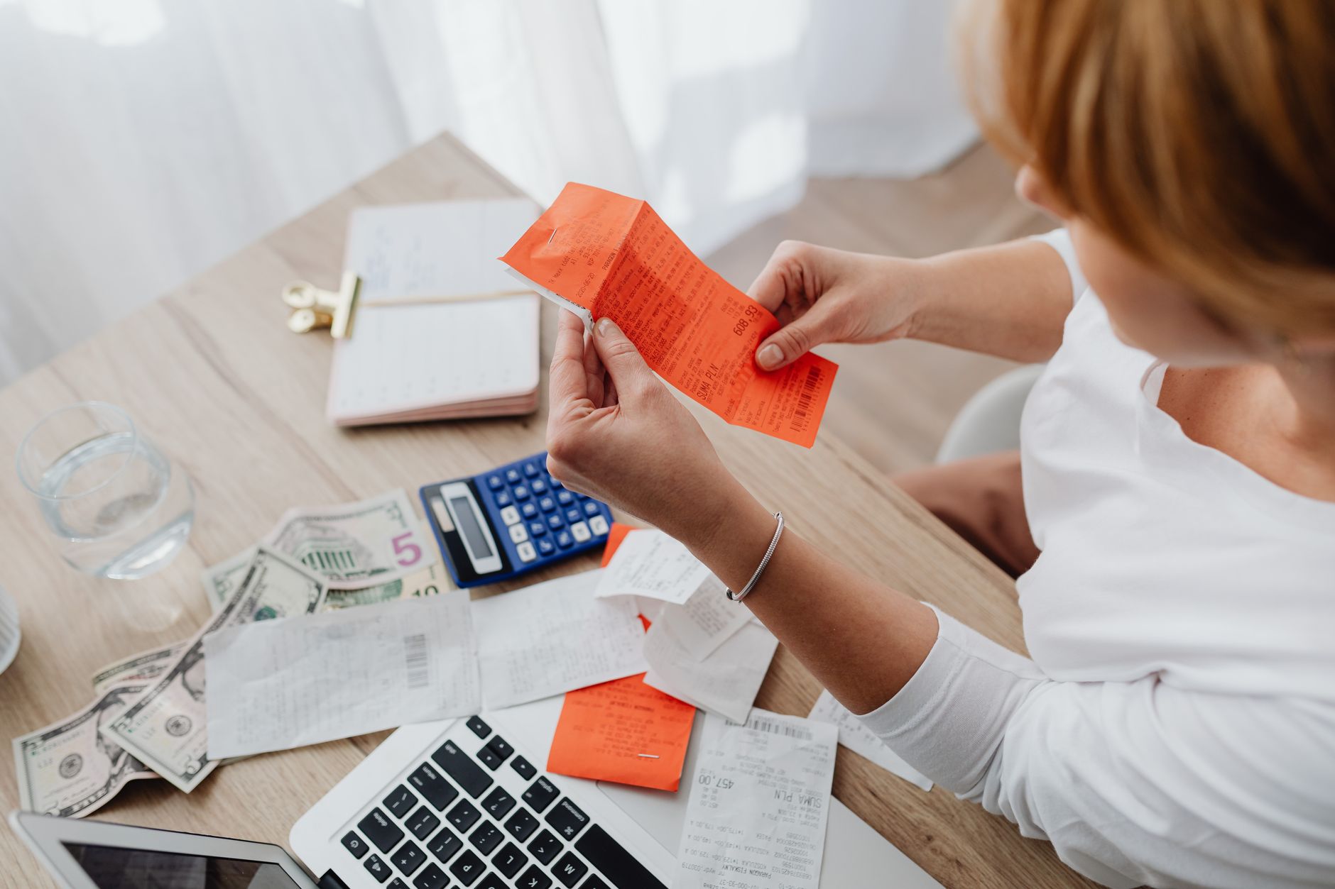 A person sorting through a drawer of documents with a calculator nearby