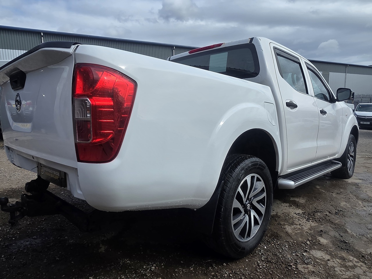 Side profile of a double-cab pickup parked on a dealer forecourt