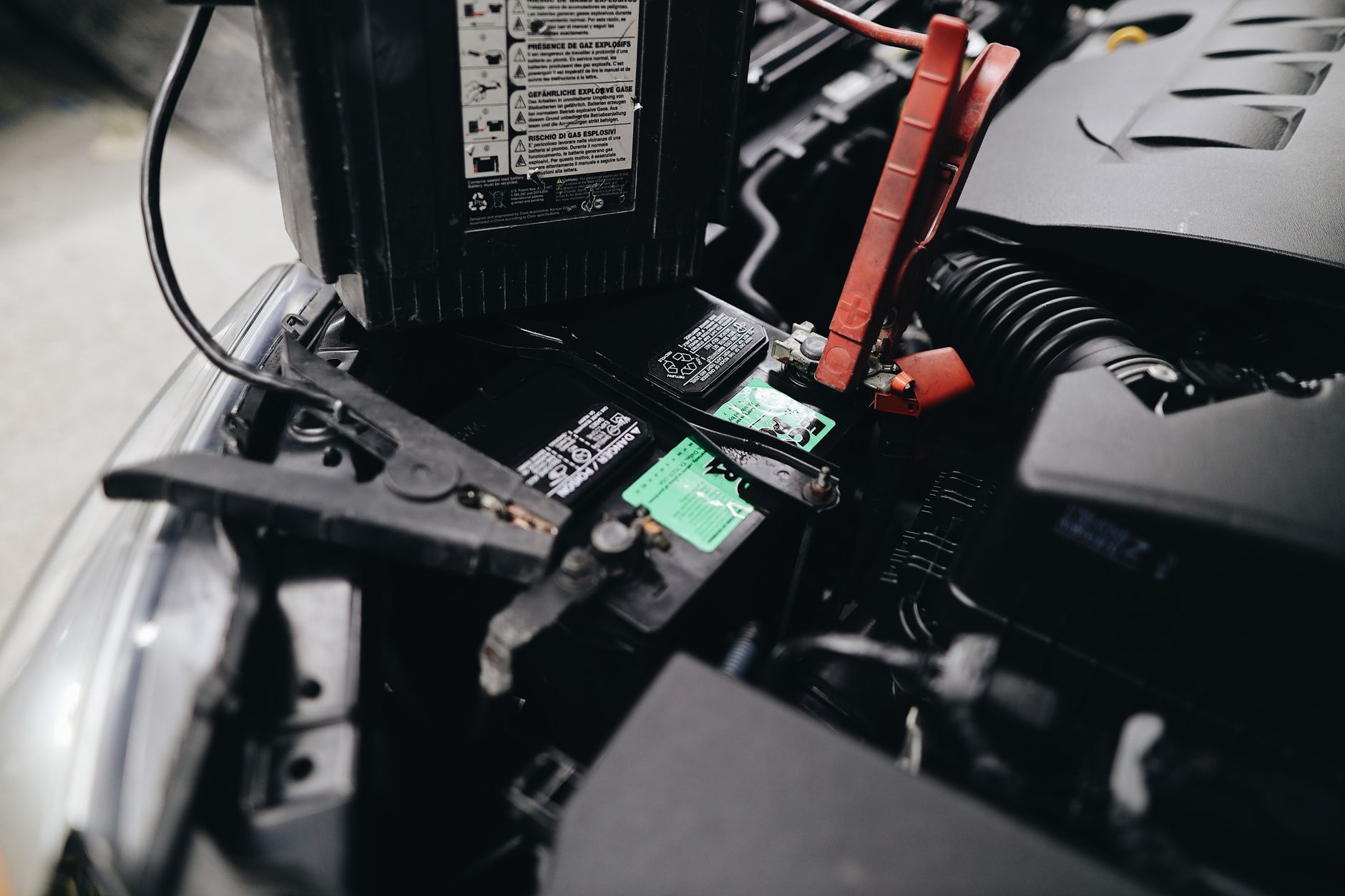 Detailed view of a vehicle battery and its terminals during a workshop inspection