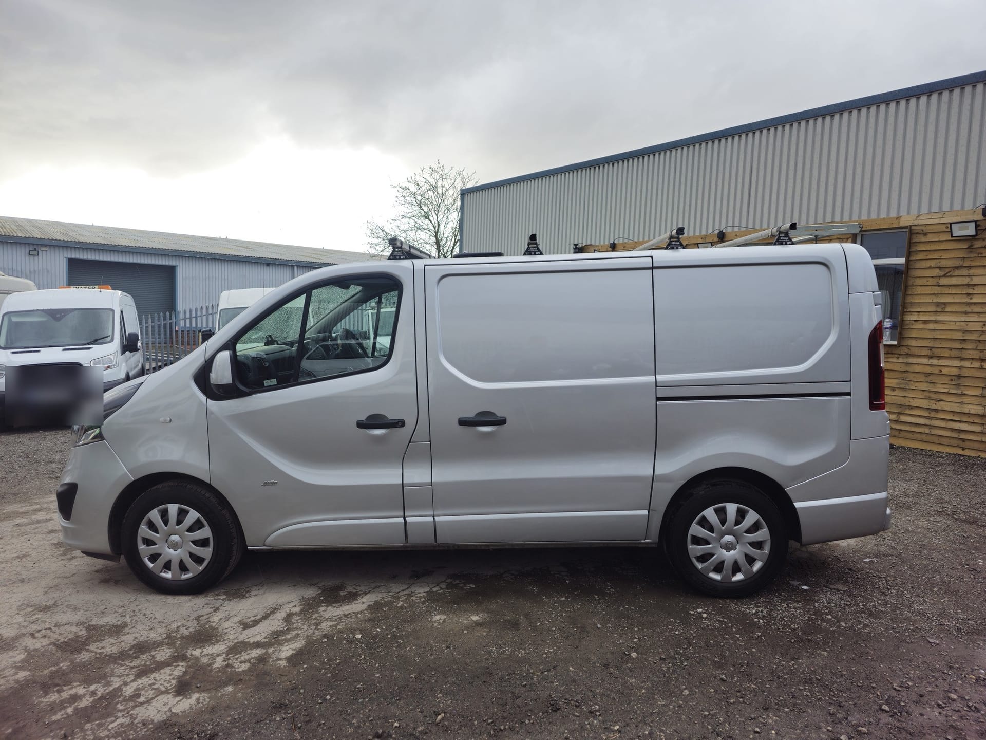 A silver Vauxhall Vivaro Sportive in side profile with a roof rack fitted
