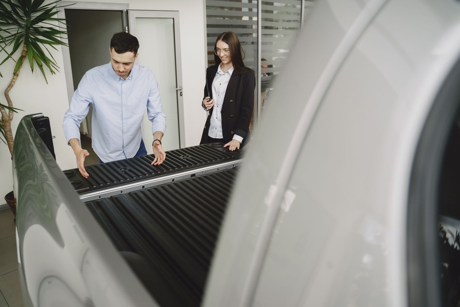 Two people looking into the open load area of a used van