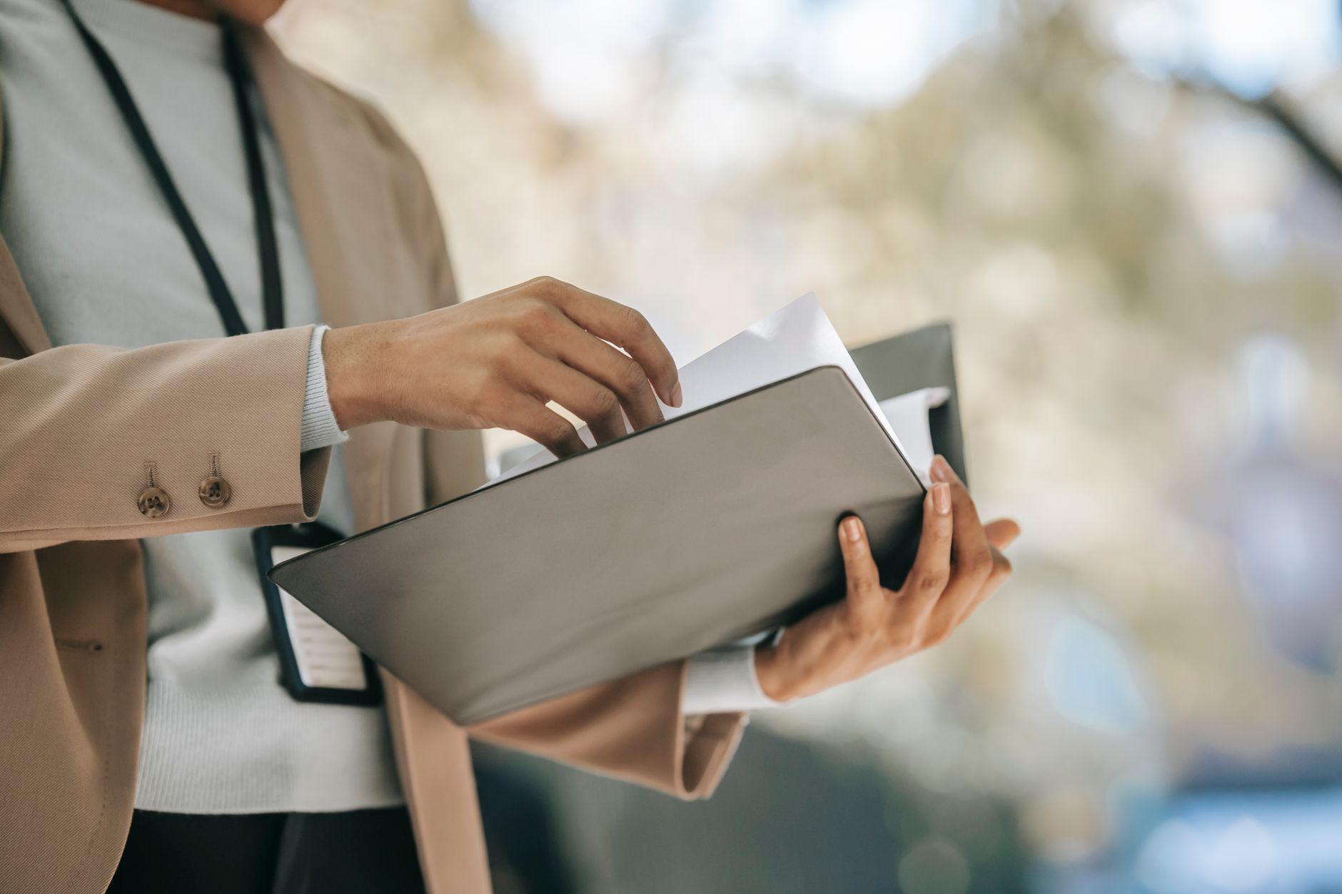 A person carrying an open folder of vehicle documents
