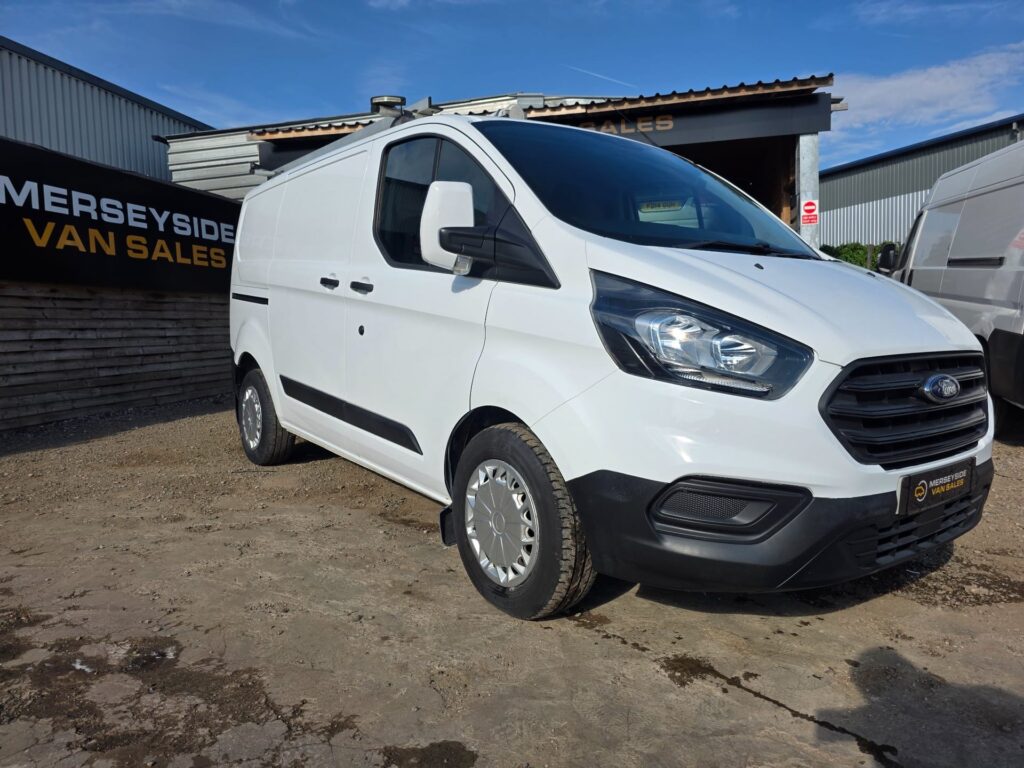 A white Ford Transit Custom on the Merseyside Van Sales forecourt, front three-quarter view in sunshine