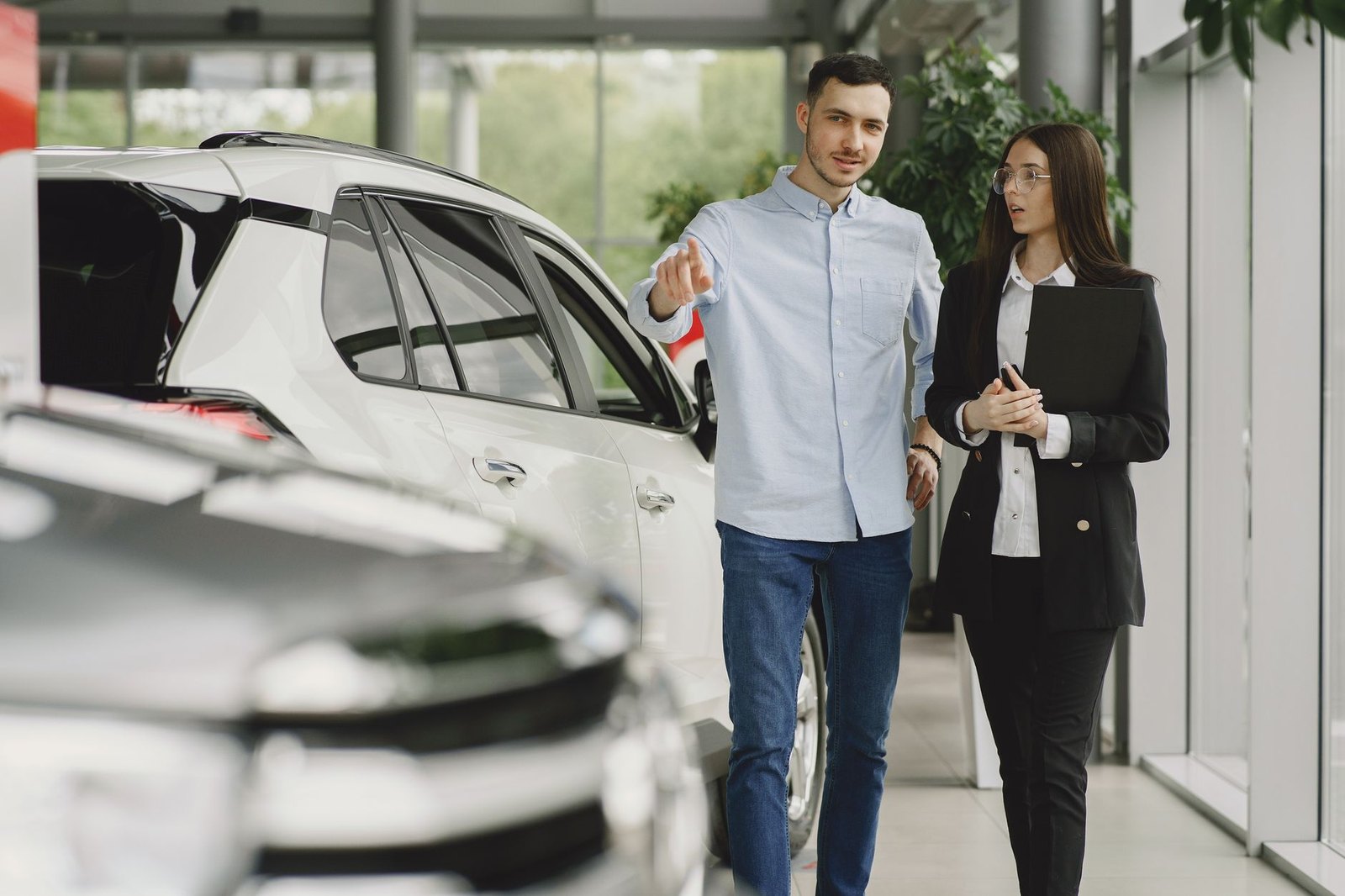 A customer and a salesperson walking through a vehicle showroom