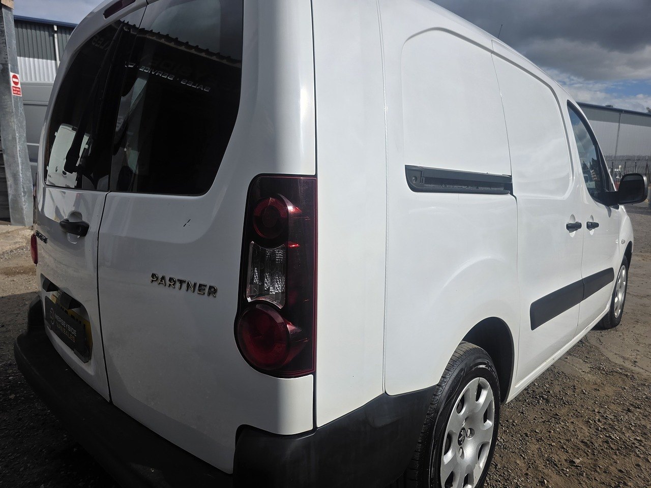 Rear three-quarter view of a white Peugeot Partner on our own forecourt