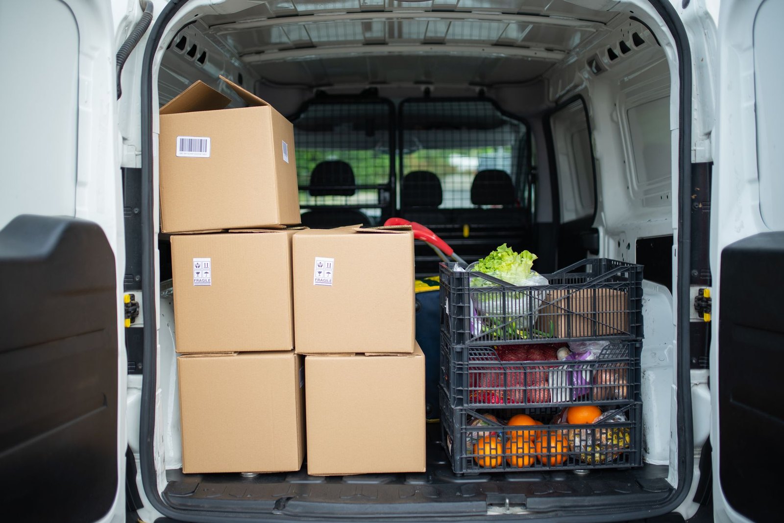 Boxes and a loaded crate in the back of a small van with the doors open