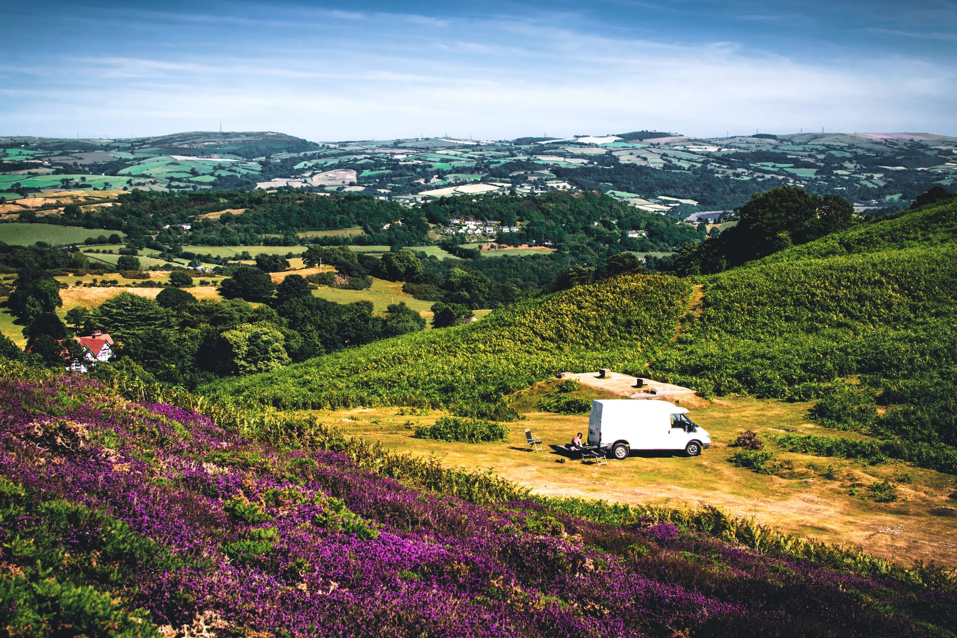 Picturesque landscape with van in Conwy, Wales showcasing hills and fields on a sunny day.