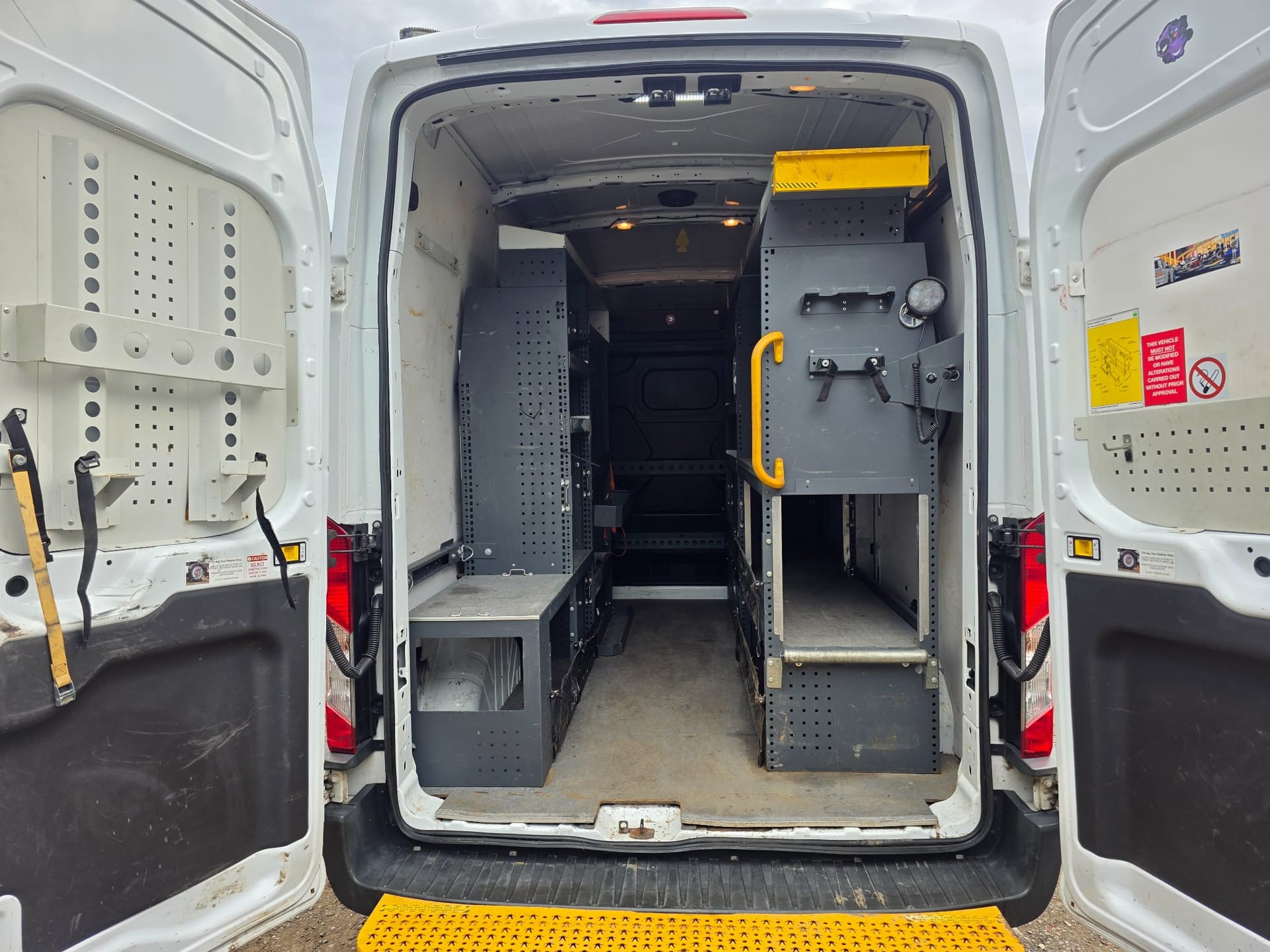 Racked load area inside a Ford Transit high-roof panel van