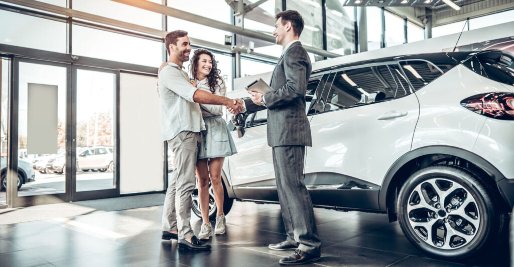 Young,couple,shaking,hands,with,sales,agent,after,a,successful - Otterbourne Car Company Ltd